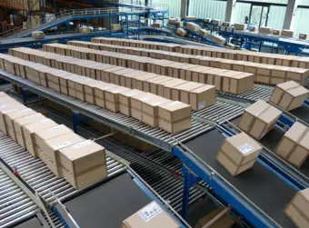 Mulitple rows of cardboard boxes on conveyor belts in a factory
