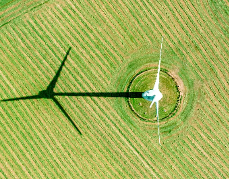 Aerial view of wind turbine in plowed field